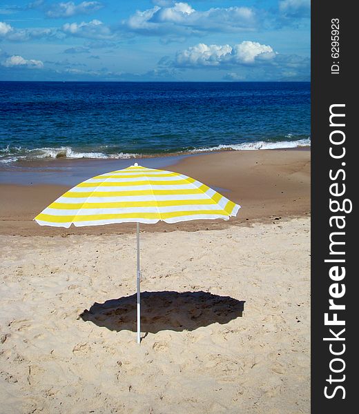 Lonely sunshade on the beach of Lagido Peniche, Portugal