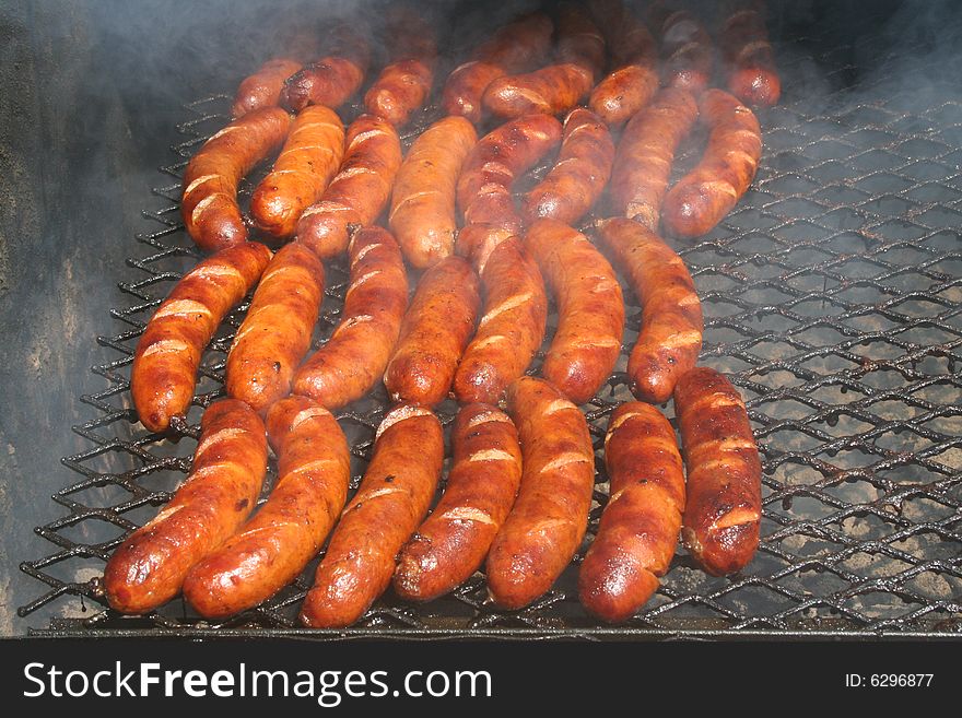 Hot links cooking on an outdoor grill.