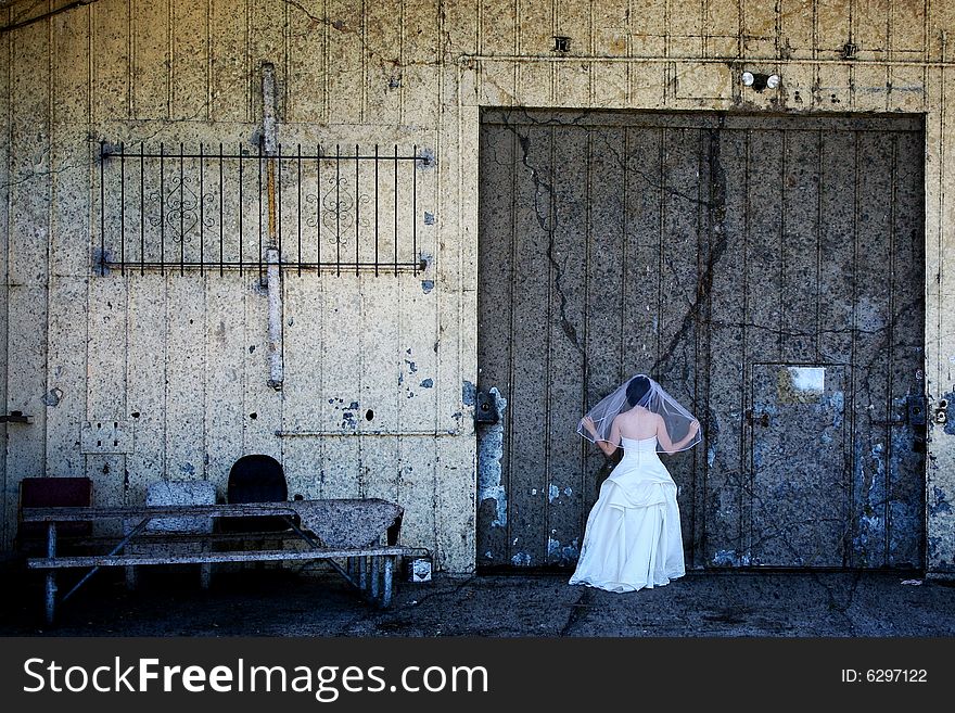 Bride in front of doors and abandoned building. Bride in front of doors and abandoned building