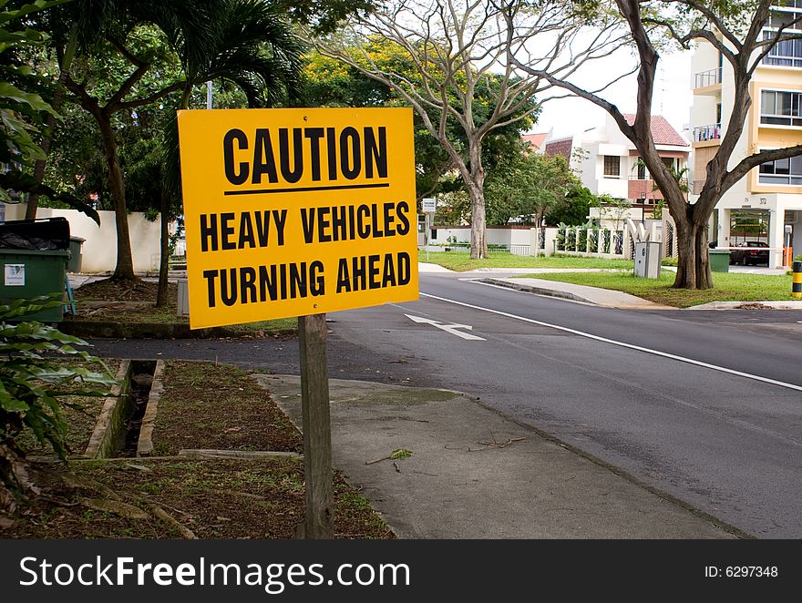 Yellow caution board, heavy vehicles turning ahead