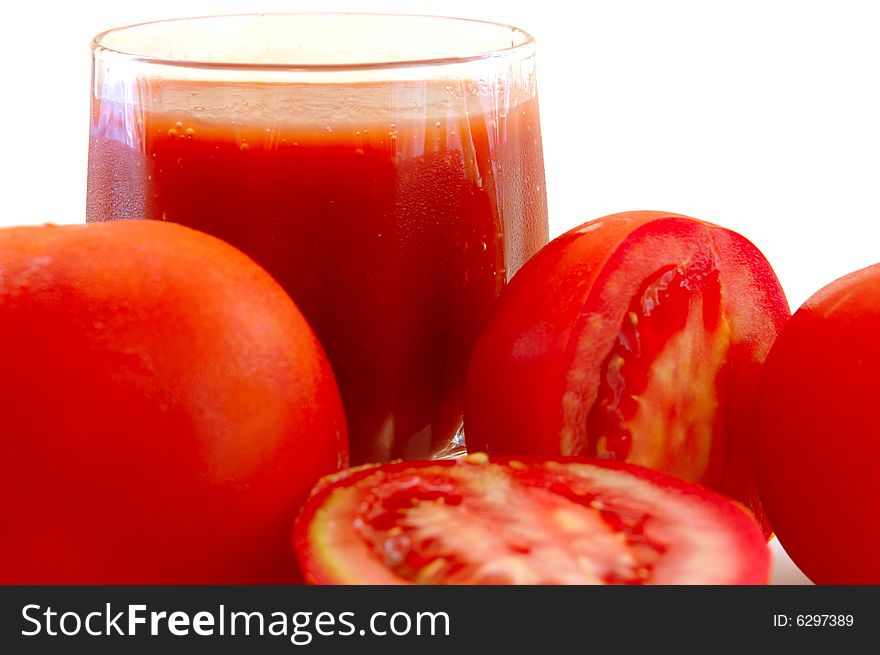Fresh tomato juice in glass and tomatoes.