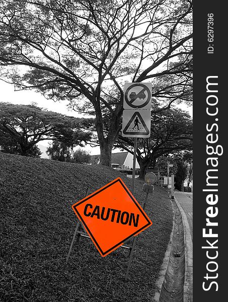 Red Caution signboard along road for traffic control