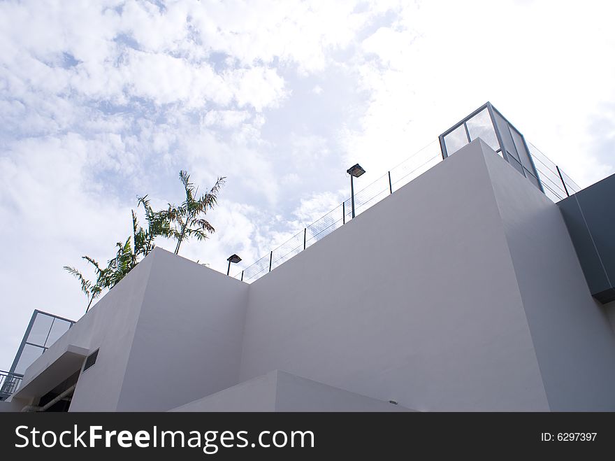 White building exterior against blue sky with clouds