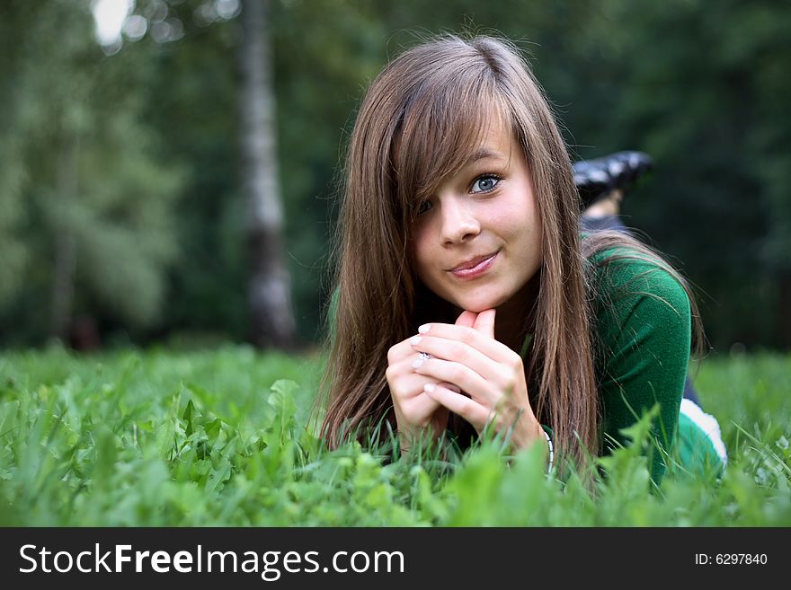 Photo presents a teenager on a grass. Photo presents a teenager on a grass.