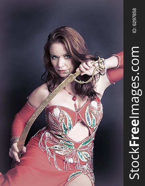 Belly dancer with tribal sword decorated in gold. Belly dancer with tribal sword decorated in gold