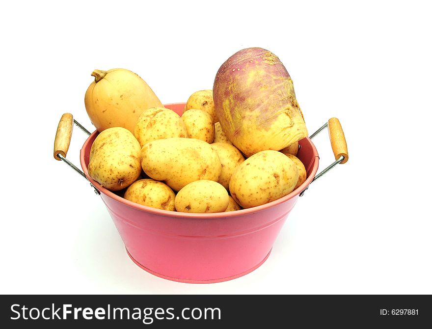 Potatoes,swede and butternut squash in a pink tin bowl. Potatoes,swede and butternut squash in a pink tin bowl