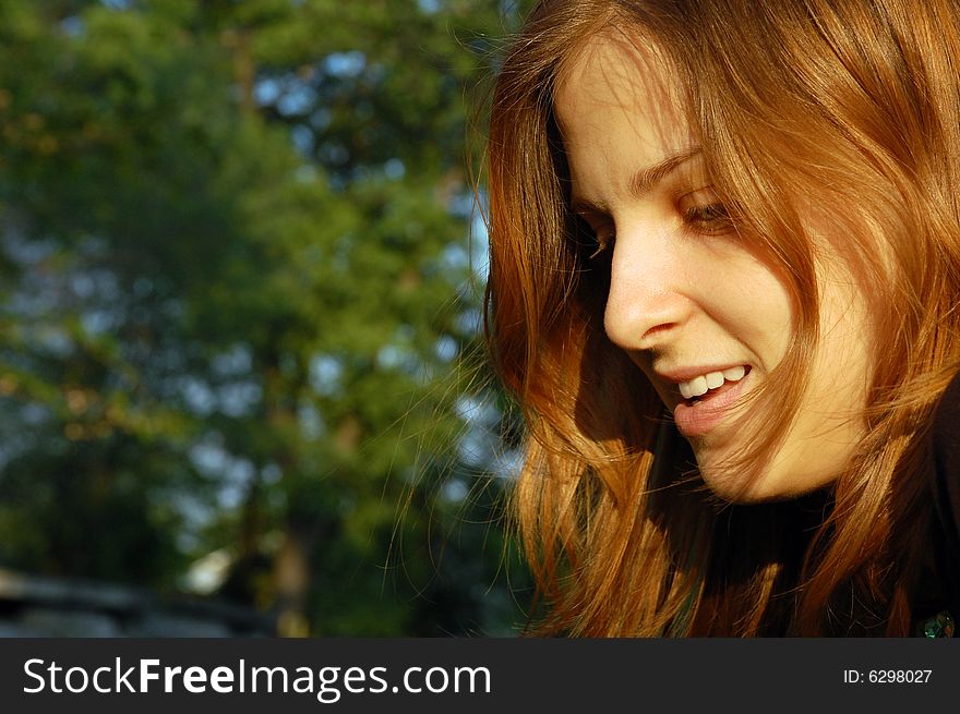 Portrait of a young woman looking down in the sunset light