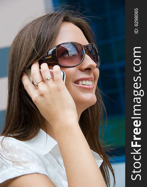 Cute smiling girl speaks on a mobile phone. Cute smiling girl speaks on a mobile phone