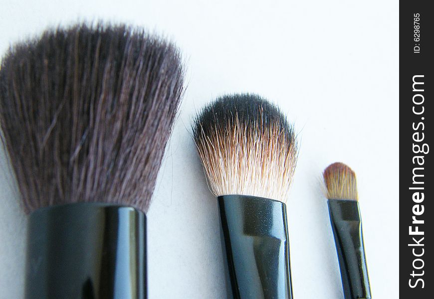 Many different size makeup brush on white background.
