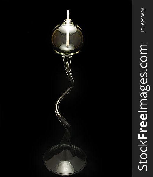 Clear glass oil lamp with a twisted stem isolated against a solid background