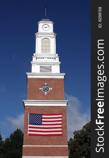 American flag on a brick and white clocktower