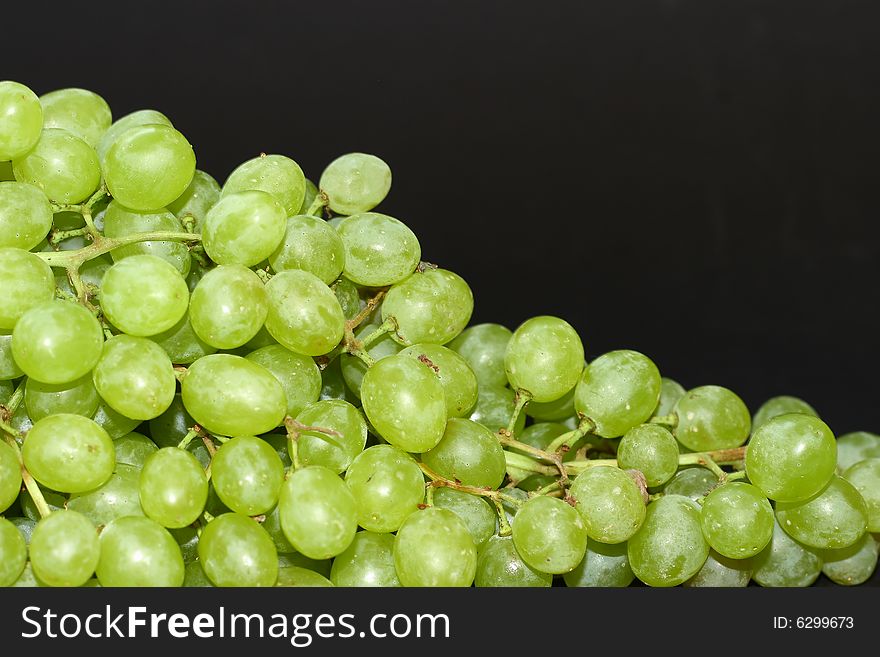 Bunch of green grapes on black background
