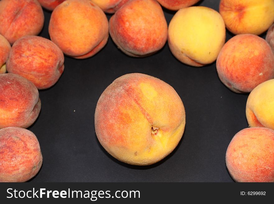 The big peach among small on a black background. The big peach among small on a black background