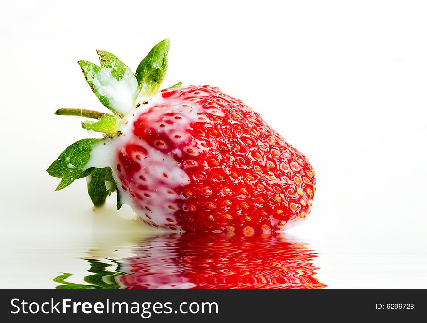 An image of red strawberry in milk close up