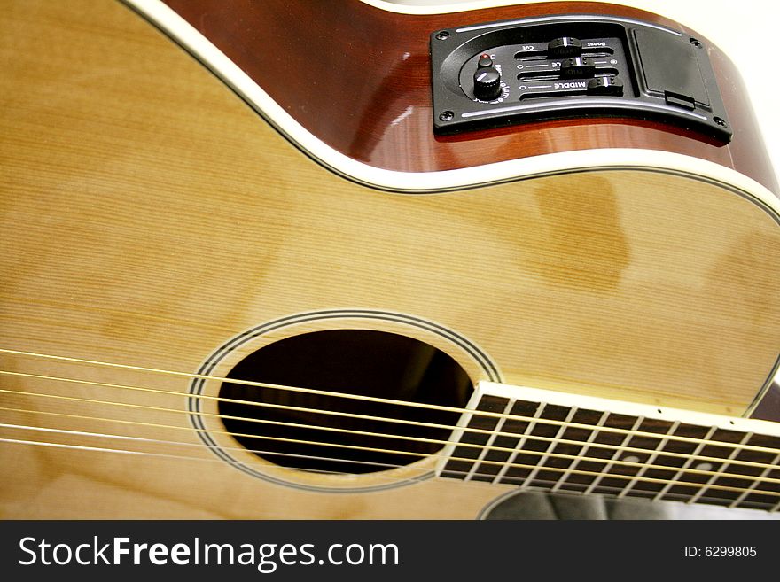 An acoustic electric guitar in light wood fully stringed