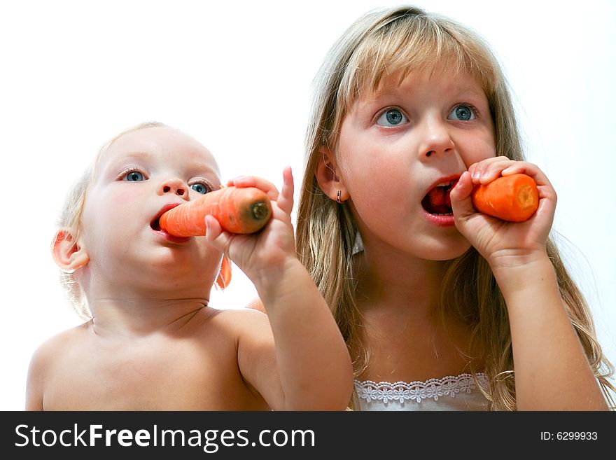 An image of two sisters eating orange carrot