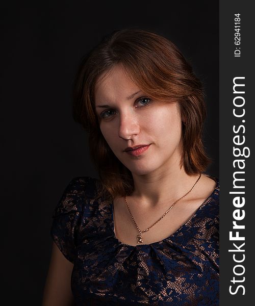 Portrait of a young beautiful girl on a dark background