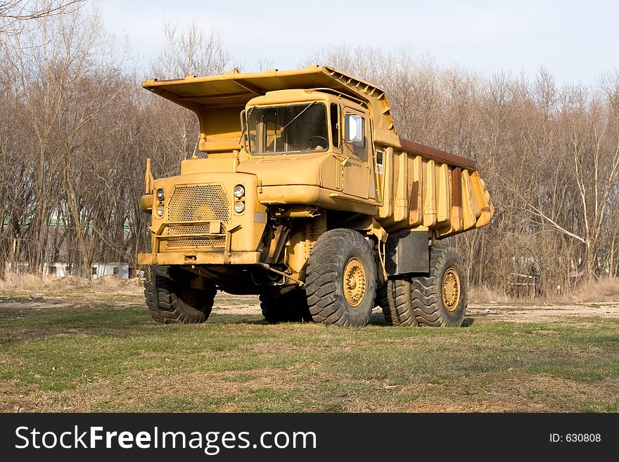 Old yellow dump truck outside