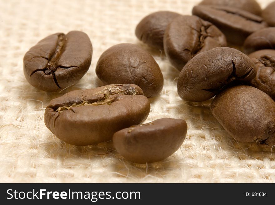 Macro shot of some coffee beans on a linen background. Macro shot of some coffee beans on a linen background.