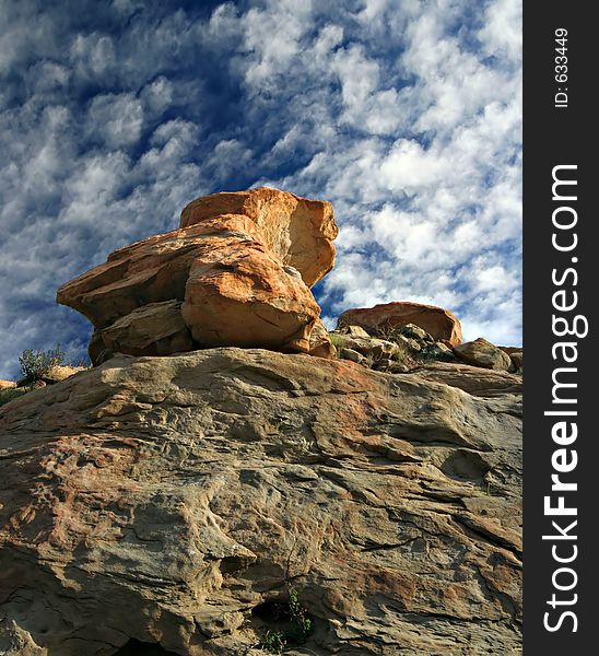 Dramatic red rock above blue sky with clouds. Dramatic red rock above blue sky with clouds