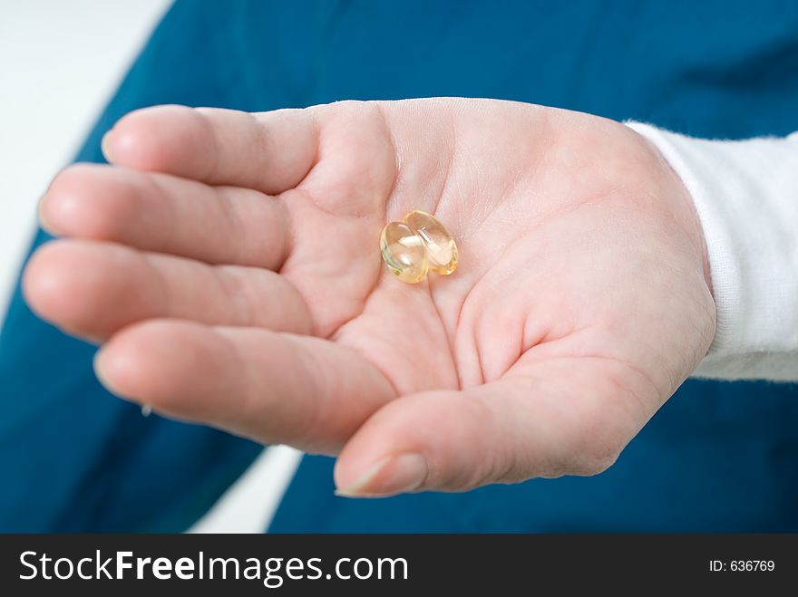 Hand holding two clear gelatin capsules. Hand holding two clear gelatin capsules