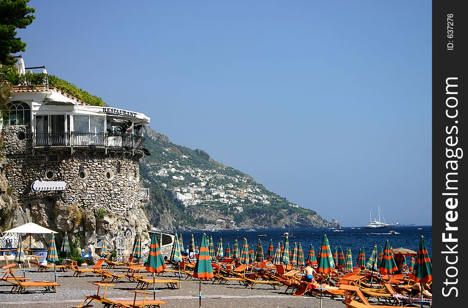 Restaurant on cliff overlooking the beach with colorful umbrellas on it. Restaurant on cliff overlooking the beach with colorful umbrellas on it