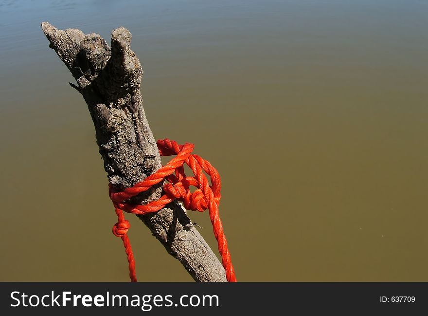 The rope from a net tied to a stick on the riverbank. The rope from a net tied to a stick on the riverbank