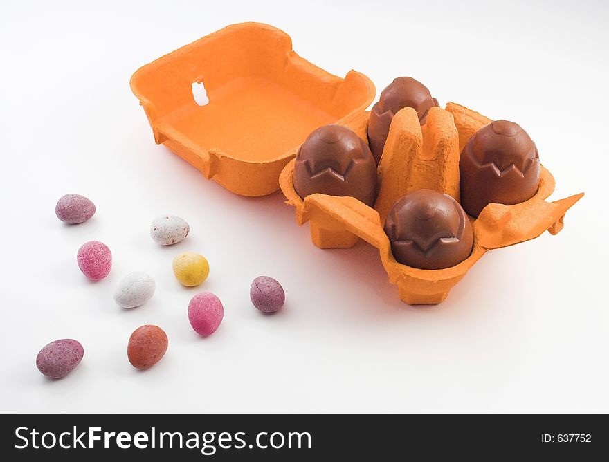 Chocolate eggs in an egg box with miniature sugar coated eggs. Chocolate eggs in an egg box with miniature sugar coated eggs