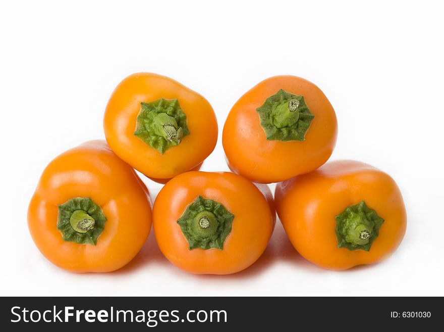 Five orange bell peppers on white background
