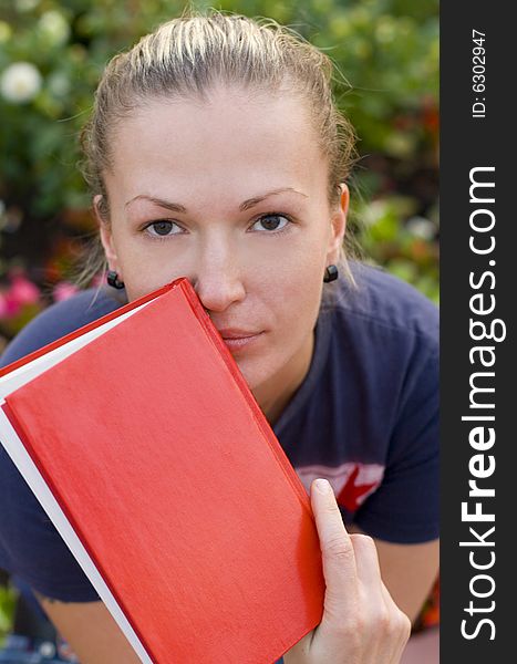 Outdoor portrait of woman with red book