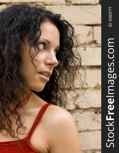 Closeup portrait of pretty brunette on brick wall background