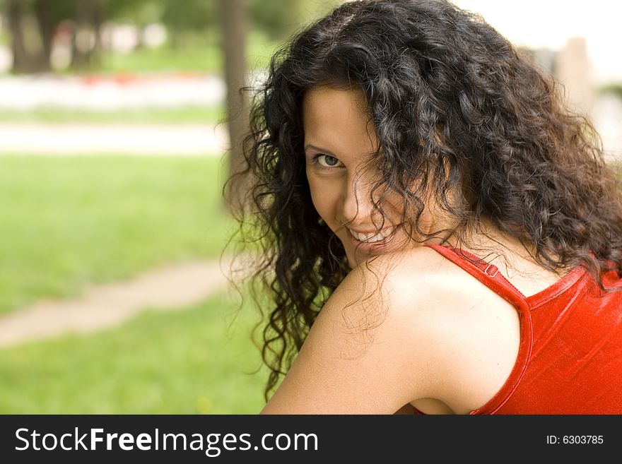 Outdoor portrait of beautiful brunet woman in red