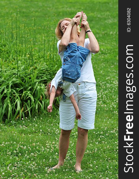 Mother playing with her son outdoors against a green background