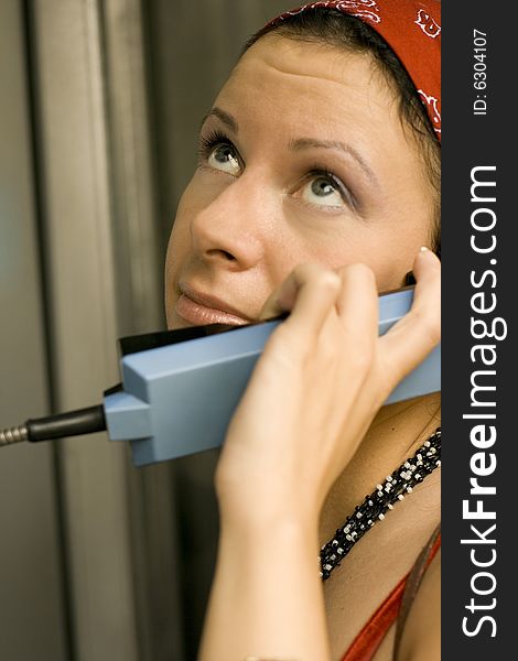 Pretty girl having a call on a public telephone. Pretty girl having a call on a public telephone