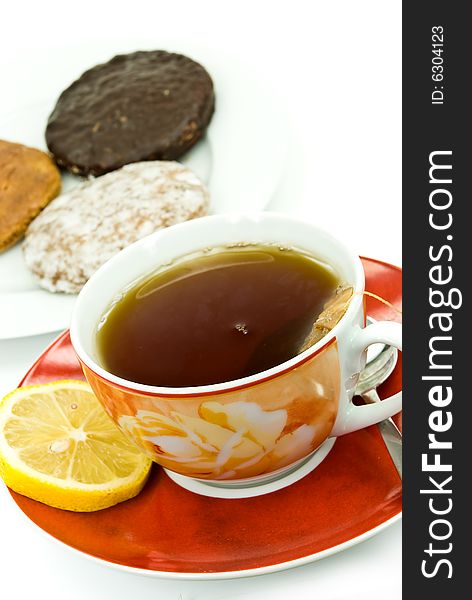 A cup of red tea with mixed cookies