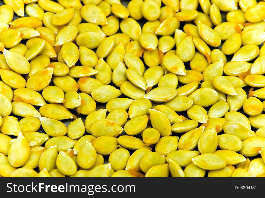 A close up shot of many pumpkin seeds.