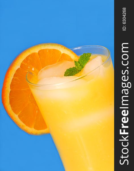 Frosty glass of orange juice with mint and ice