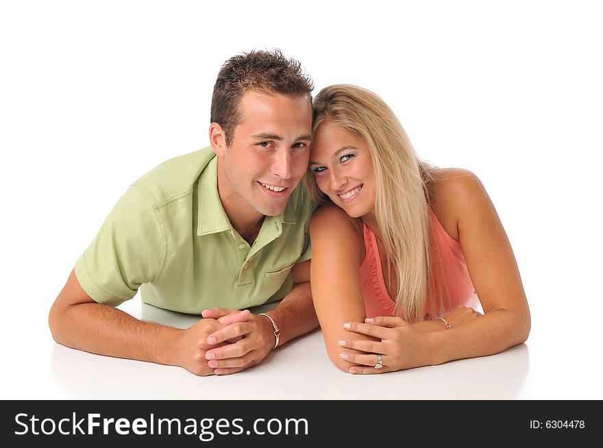 Young couple having fun lying down on the floor isolated on white