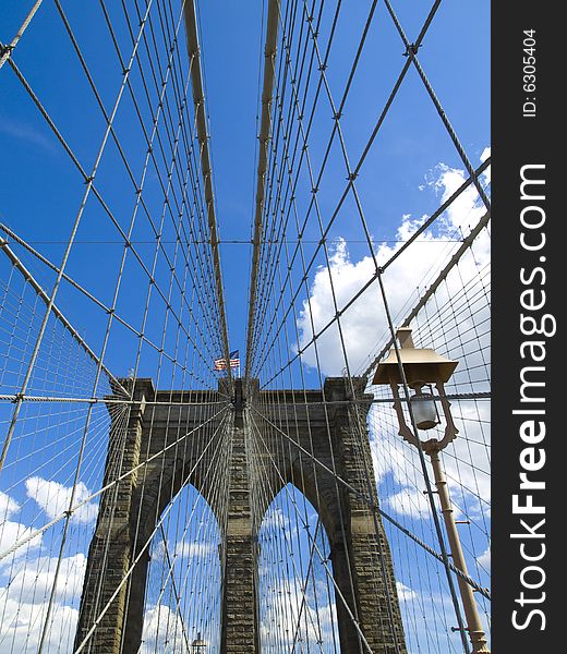 A view of the Brooklyn bridge with a blue sky on the background.