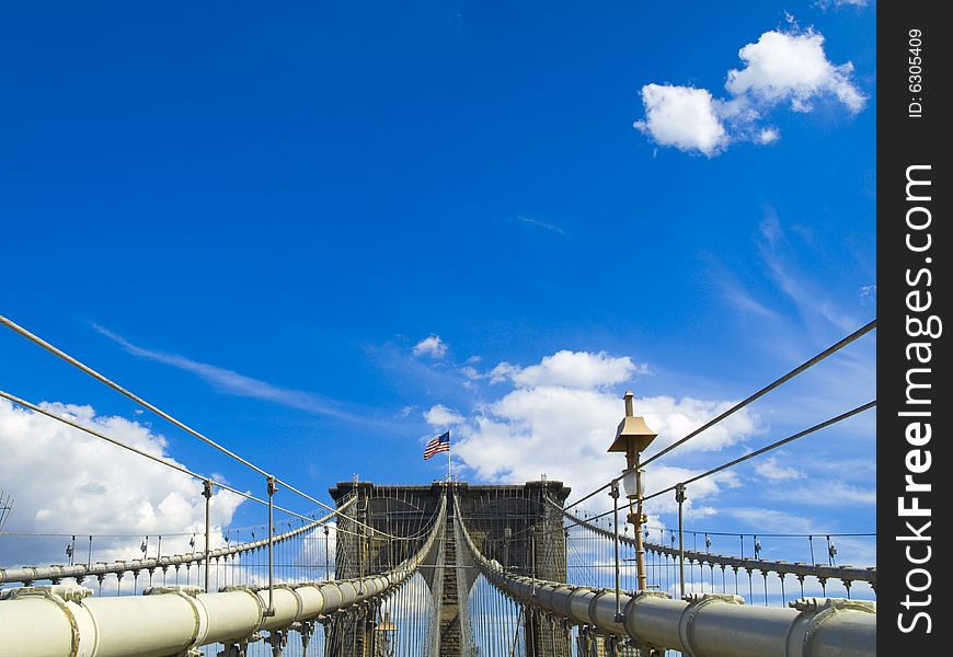 A view of the Brooklyn bridge with a blue sky on the background.