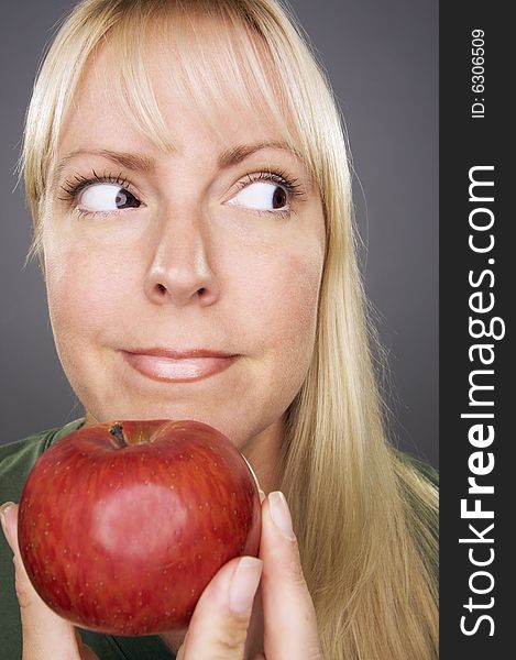 Beautiful Woman With Apple Against A Grey Background.