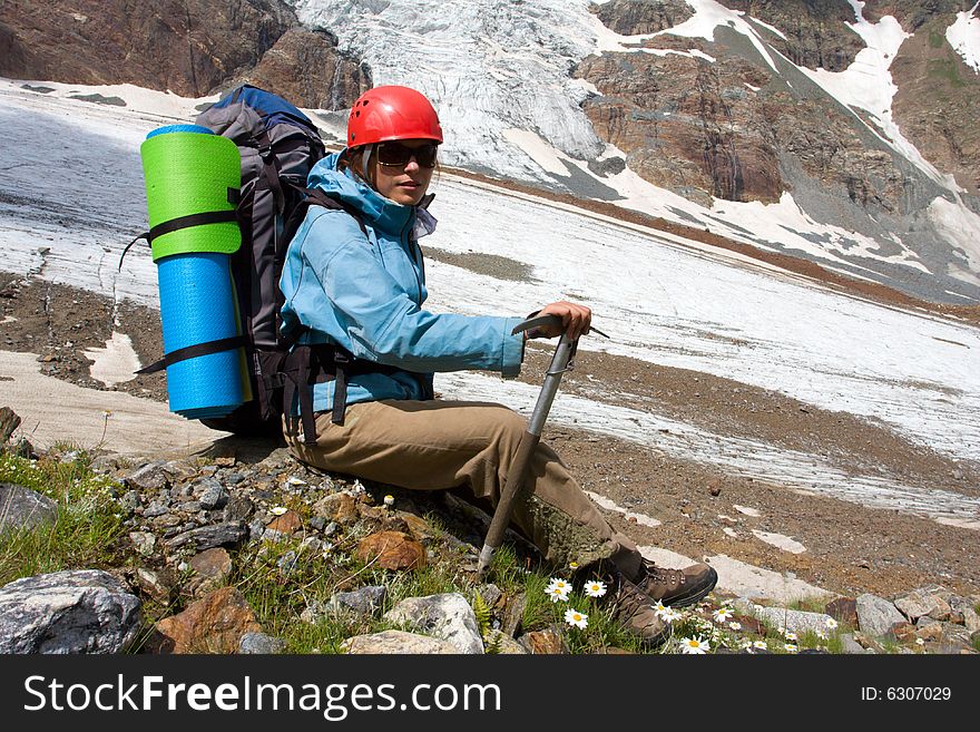 Backpacker girl with ice-axe in high Caucasus mountains