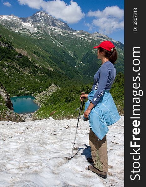 Hiker girl looking to mountain lake. Hiker girl looking to mountain lake