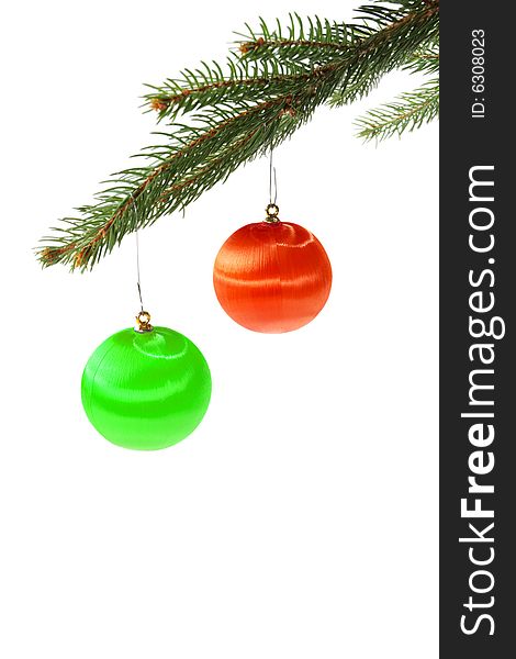 Green and red christmas balls on spruce branch isolated on white. Green and red christmas balls on spruce branch isolated on white