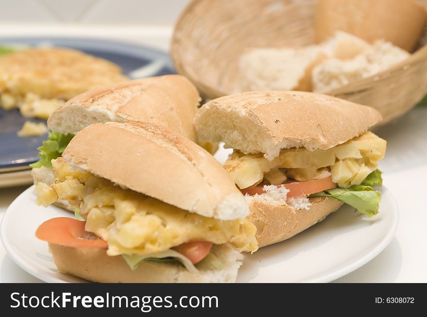 A hand making an spanish omelet sandwich