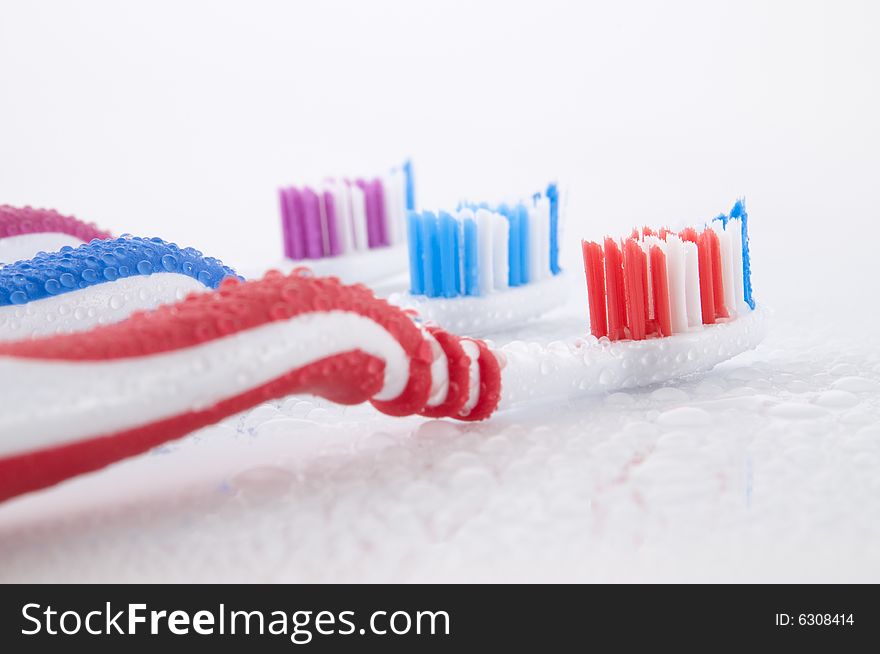 Close up of three vibrant toothbrushes isolated on white