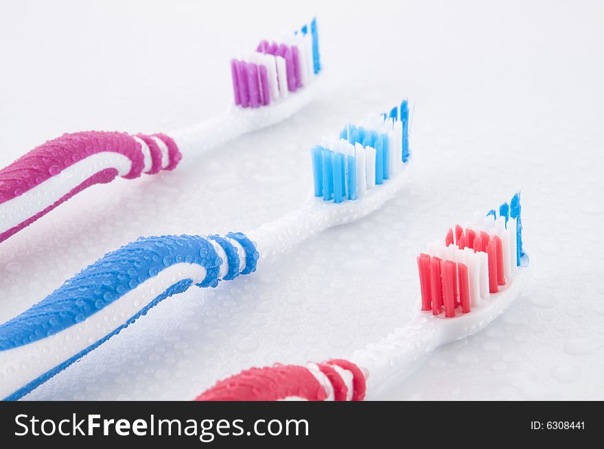 Close up of three vibrant toothbrushes isolated on white. Close up of three vibrant toothbrushes isolated on white