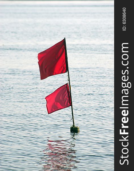 Fishing Net Flag. Red flag in the sea marking fishing net at the ocean floor.