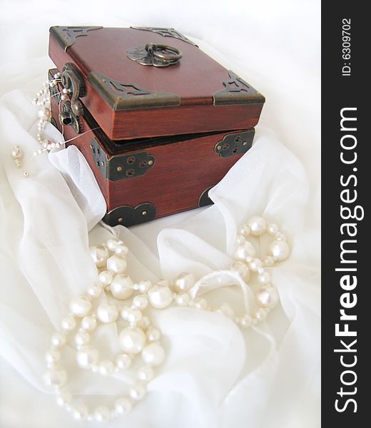 Casket of of pearl necklace on white material. Casket of of pearl necklace on white material