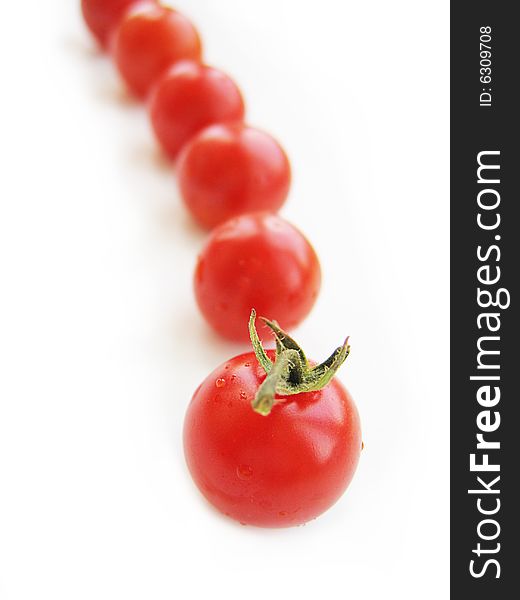 Red cherry tomatoes in line isolated on white